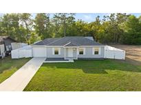 Charming one-story home with a well-manicured lawn, white picket fence, and a single-car garage for convenient parking at 430 Spring Dr, Ocala, FL 34472