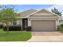 Charming single-story home with a well-manicured lawn and a brick driveway at 5610 Nw 37Th Lane Rd, Ocala, FL 34482