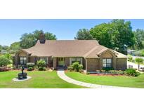 Charming brick home featuring a well-manicured front lawn and classic architectural details at 585 Summerhaven Dr, Debary, FL 32713