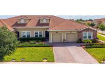 Beautiful single Gathering home featuring a red tile roof, manicured lawn, and a two-car garage at 1079 Quaker Ridge Ln, Davenport, FL 33896