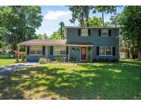 Charming two-story home featuring a well-maintained lawn and traditional architectural details at 1228 Oakwood Ave, Daytona Beach, FL 32114