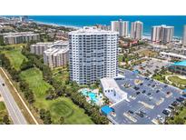Stunning aerial view of a high-rise condo building with a pool, golf course, and ocean views at 2 Oceans West Blvd # 1007, Daytona Beach, FL 32118