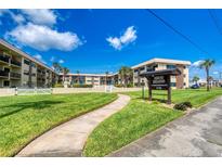Beautiful view of the Ormond Breakers Condominium with manicured lawn and a clear blue sky at 2100 Ocean Shore Blvd # 1120, Ormond Beach, FL 32176