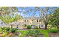 Spacious two-story home with a manicured front yard and mature trees at 28 Shadowcreek Way, Ormond Beach, FL 32174