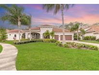 Inviting front yard with lush green grass, swaying palm trees, and a charming home with a terracotta roof at 2811 S Asciano Ct, New Smyrna Beach, FL 32168