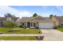 Charming single-story home featuring a well-manicured lawn, attached garage, and quaint landscaping at 1020 Hornbeam St, Oviedo, FL 32765