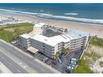 Aerial view of a beachfront resort, showcasing direct beach access, a pool, and ample parking at 1233 N Atlantic Ave # 3090, Daytona Beach, FL 32118