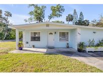 Charming one-story home featuring a well-manicured lawn and cozy front porch at 128 Oakridge Ave, Edgewater, FL 32132