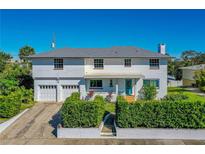 Charming two-story home boasts a crisp white facade, complemented by manicured greenery and a vibrant turquoise front door at 1613 Crescent Ridge Rd, Daytona Beach, FL 32118