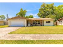 Charming single-story home featuring a well-maintained lawn, stone accents and an attached two car garage at 1650 Jacobs Rd, South Daytona, FL 32119