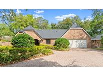 Charming brick home featuring manicured landscaping and an inviting brick paver driveway at 1841 Spruce Creek Blvd, Port Orange, FL 32128