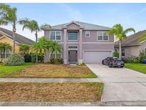 Charming two-story home with a well-maintained yard, palm trees, and a two-car garage at 1929 Cove Point Rd, Port Orange, FL 32128