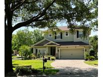 Charming two-story home with a brick driveway, lush landscaping, and a cozy, inviting curb appeal at 201 Asterbrooke Dr, Deland, FL 32724
