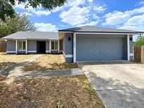 Charming single-story home with a gray exterior, new roof, and attached two-car garage at 206 Westmoor Bnd, Orlando, FL 32835