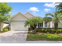 Charming single-story home with a well-manicured lawn and tropical landscaping including beautiful palm trees at 220 Asterbrooke Dr, Deland, FL 32724
