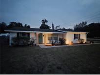 Charming single-story home with landscaped front yard and a welcoming porch at dusk at 2204 Poinsettia Dr, Deland, FL 32724