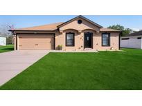 Charming single-story home featuring a well-manicured lawn, neutral paint, attached garage and a welcoming front entrance at 2448 Newmark Dr, Deltona, FL 32738