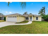 Charming single-story home featuring a well-manicured lawn and a two-car garage and bright exterior color at 2526 Chester Ave, New Smyrna Beach, FL 32168