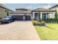 Charming two-story home with a tile roof, landscaped yard, brick driveway, and two-car garage at 260 Teddy Rushing St, Debary, FL 32713
