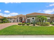 Inviting home featuring a tile roof, manicured lawn, and lush landscaping at 2814 S Asciano Ct, New Smyrna Beach, FL 32168