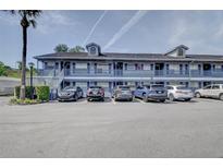 Exterior shot of a multi-Gathering building, featuring parking spaces and a palm tree on a sunny day at 313 Dirksen Dr # B15, Debary, FL 32713