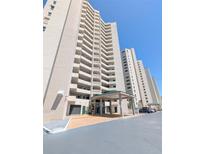 A grand entrance of a high-rise condo building with covered parking and well-maintained landscaping at 3311 S Atlantic Ave # 604, Daytona Beach Shores, FL 32118