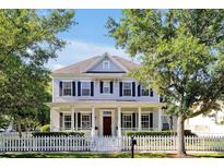 Charming two-story home featuring a welcoming front porch, white picket fence, and well-manicured landscaping at 3698 Lower Park Rd, Orlando, FL 32814
