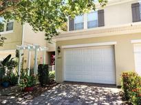 Townhouse with a two-car garage and a beautifully landscaped front yard at 6043 Strada Isle Way, Orlando, FL 32835