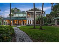Stunning two-story home with a green metal roof, manicured lawn, and a charming walkway leading to the entrance at 6317 Palmas Bay Cir, Port Orange, FL 32127
