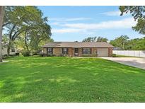 Charming single-story brick home with a well-manicured lawn and attached garage at 672 Swarthmore Dr, Deland, FL 32724