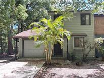 Charming townhome featuring an attached garage and a lovely palm tree in the front yard at 805 N Clake St, Deland, FL 32724