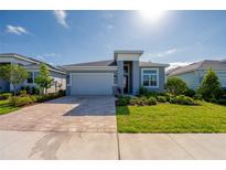 Beautiful single-story home with a brick paver driveway and well-maintained landscaping at 887 Lake Hill Way, Deland, FL 32724