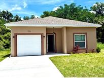 Inviting single-story home with a well-maintained lawn, one-car garage, and neutral-toned exterior at 926 Clover St, Deland, FL 32720