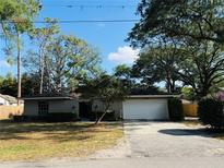 Charming single-story home featuring an attached two-car garage, inviting curb appeal, and mature trees at 1120 Arden St, Longwood, FL 32750