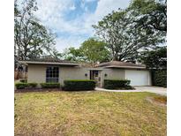 Charming single-story home featuring a well-maintained lawn, mature trees, and an attached two-car garage at 1120 Arden St, Longwood, FL 32750