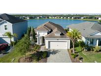Stunning single Gathering home with lake view, manicured lawn, and paver driveway at 133 Azure Mist Way, Daytona Beach, FL 32124