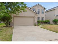 Two story home featuring a large garage, neutral paint and well maintained landscaping in a suburban neighborhood at 1922 Cove Point Rd, Port Orange, FL 32128