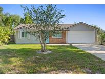 Charming single Gathering home featuring a brick facade, neutral colors, and a well maintained front yard at 2416 Candlewick St, Deltona, FL 32738