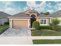 Charming single-Gathering home featuring a two-car garage, landscaped yard, and neutral color palette at 2435 Pawtucket Pass, Mount Dora, FL 32757