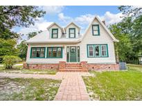 Charming two-story home with a brick pathway and lovely green accents on the windows and front door at 257 Huntington Dr, Deland, FL 32724