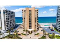 Stunning oceanfront condo building with multiple floors, palm trees, and ample parking spaces at 3023 S Atlantic Ave # 4020, Daytona Beach, FL 32118