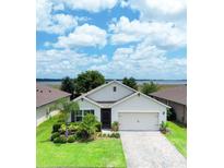 Beautiful one-story home featuring a well-maintained lawn, complemented by decorative landscaping and a neutral color scheme at 343 Lazio Cir, Debary, FL 32713