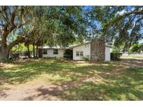 Charming single-story home with a stone chimney and beautiful mature trees in the front yard at 4145 Rambler Ave, St Cloud, FL 34772