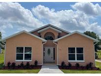 Charming single-story home featuring a landscaped front yard and inviting entrance at 707 Hamilton St, New Smyrna Beach, FL 32168