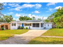 Charming single-story home with a well-manicured lawn, blue door, and solar panels under a bright blue sky at 738 Lindley Blvd, Deland, FL 32724