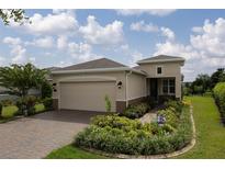 Charming single-story home with a brick driveway, well manicured lawn and colorful landscaping at 1118 Avery Meadows Way, Deland, FL 32724