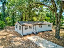 Charming single-story home boasts a fresh exterior with white siding and a well-manicured front yard at 165 S Massachusetts Ave, Deland, FL 32724