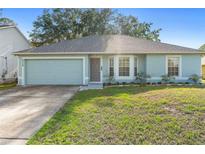 Charming single-story home with a well-maintained lawn and a two-car garage at 2110 3Rd Ave, Deland, FL 32724