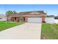 Charming brick home with a two-car garage and well-maintained front yard at 2287 Belen Dr, Deltona, FL 32738