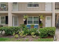 Condo with cozy front patio featuring blue chairs, lush landscaping, and hanging plants at 2500 Lee Rd # 134, Winter Park, FL 32789